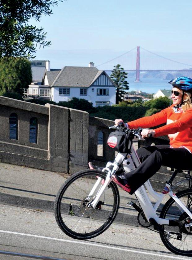 Woman riding up the hilly streets of San Francisco with ease on an Electric Bike