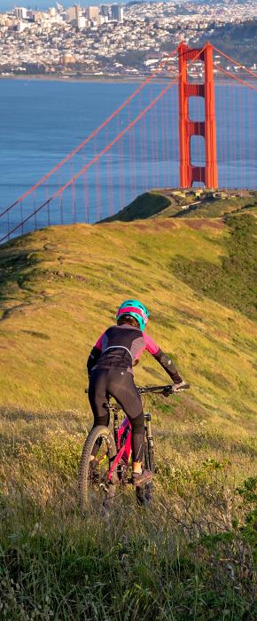 Mountain biker conquering the off-road trails in the Marin Headlands with incredible views of the Golden Gate Bridge and San Francisco