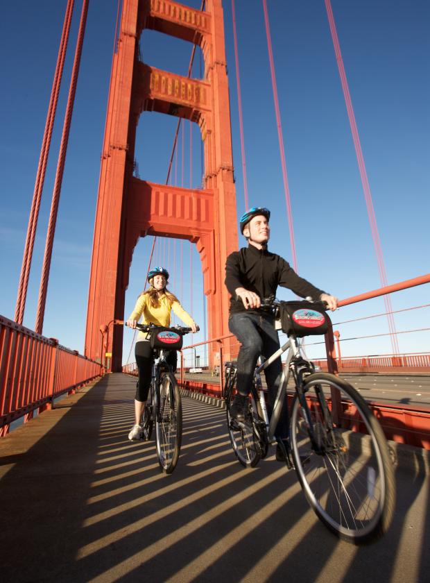 Couple riding across the Golden Gate Bridge on a beautiful clear day
